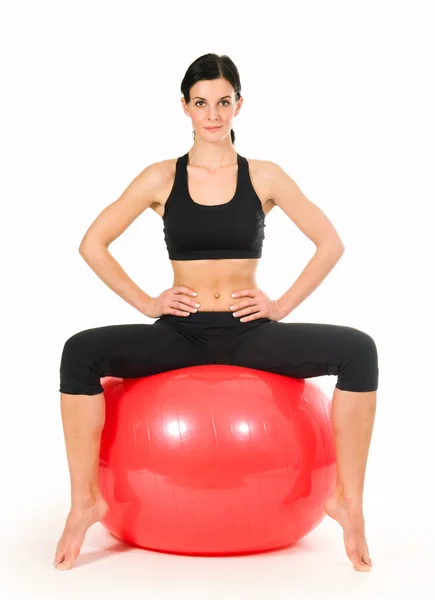 Mujer morena haciendo ejercicio con una pelota de pilates — Foto de Stock