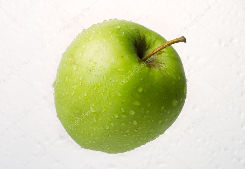 Dewy green apple on dewy background