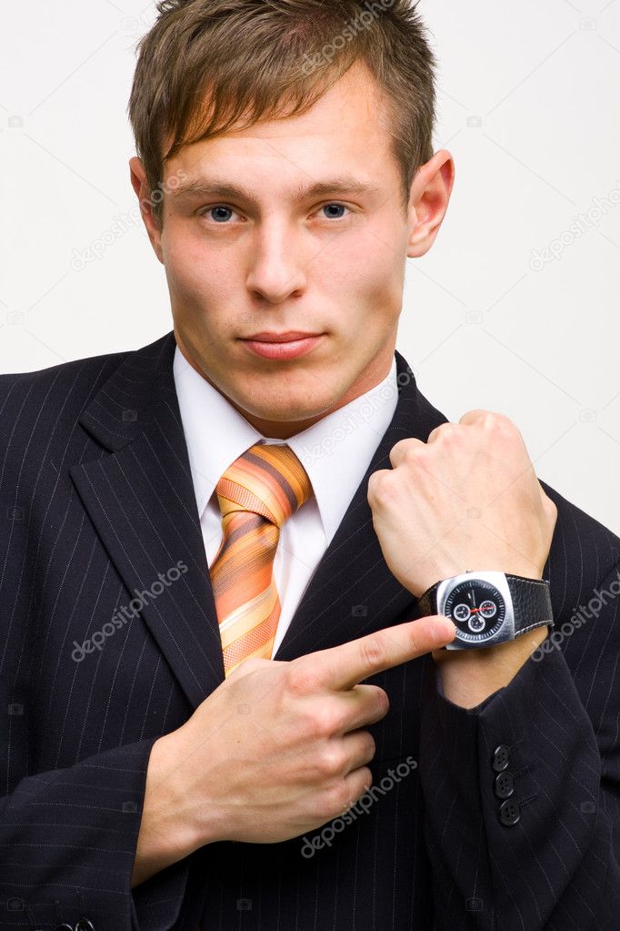 Angry young businessman showing time