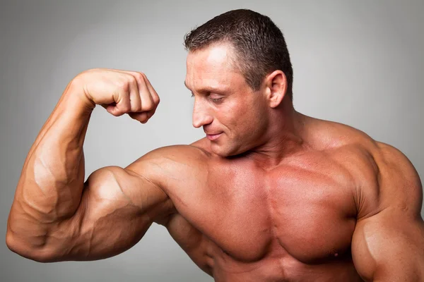 Homme musclé fléchissant ses biceps — Photo