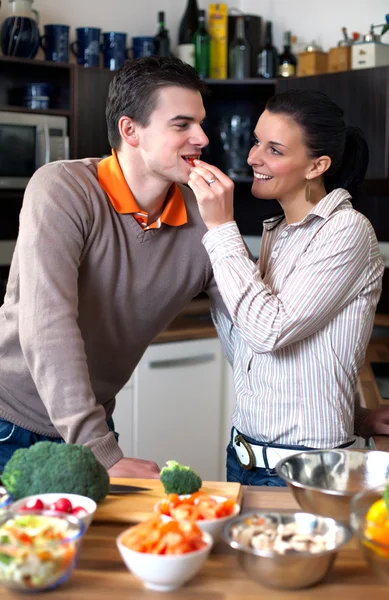 Молодая пара делает и дегустирует салат — стоковое фото