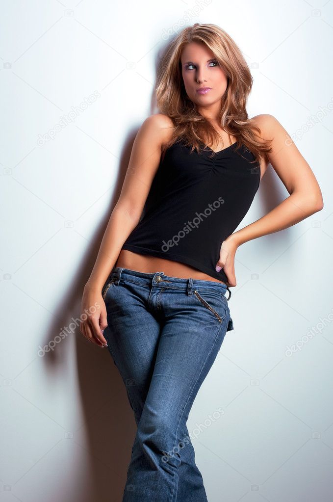 Young attractive model standing near wall