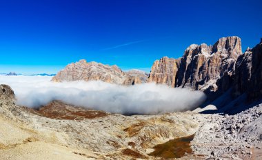 Dolomities - mountain peak emerges from the clouds clipart