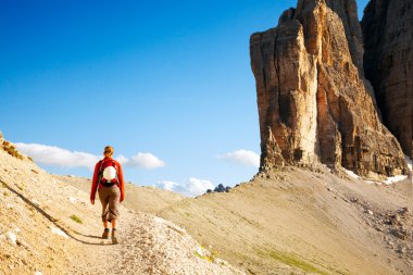 Young woman with backpack walking through rocky land