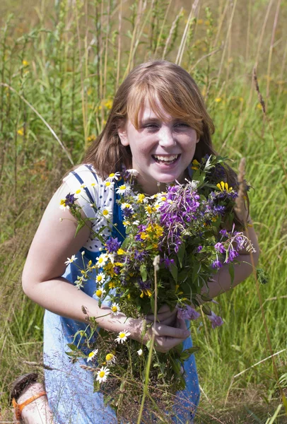 La fille rouge heureuse avec des fleurs — Photo