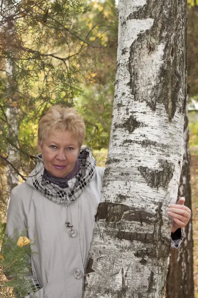 Žena středního věku v podzimním lese — Stock fotografie
