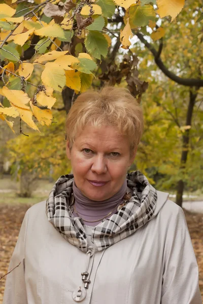 Žena středního věku v podzimním parku — Stock fotografie