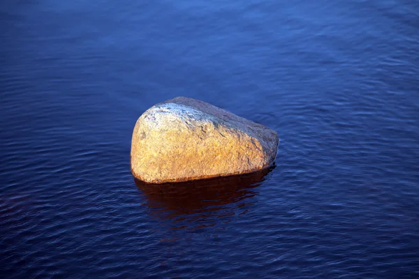 Stone on blue water — Stock Photo, Image