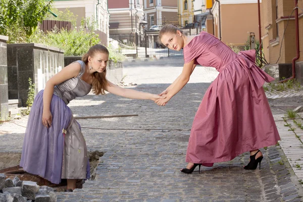 Дві дівчини в красивих сукнях на сходах — стокове фото