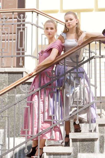 Две девушки в красивых платьях на лестнице — стоковое фото
