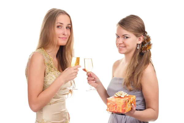 Two girls celebrate Christmas with gifts and glasses in their hands — Stock Photo, Image