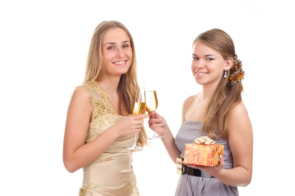 Две девушки празднуют Рождество с подарками и стаканами в руках — стоковое фото
