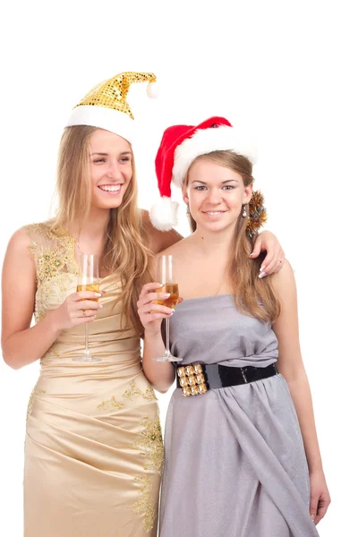 Две девушки празднуют Рождество с подарками и стаканами в руках — стоковое фото
