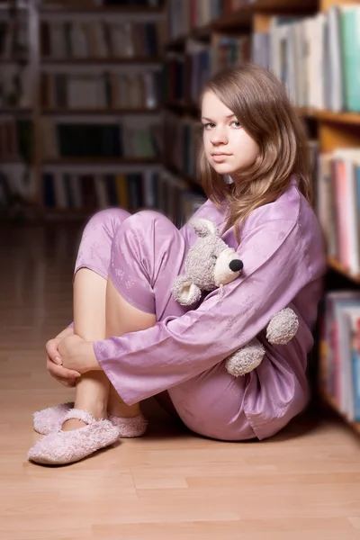 A menina de pijama rosa na biblioteca — Fotografia de Stock