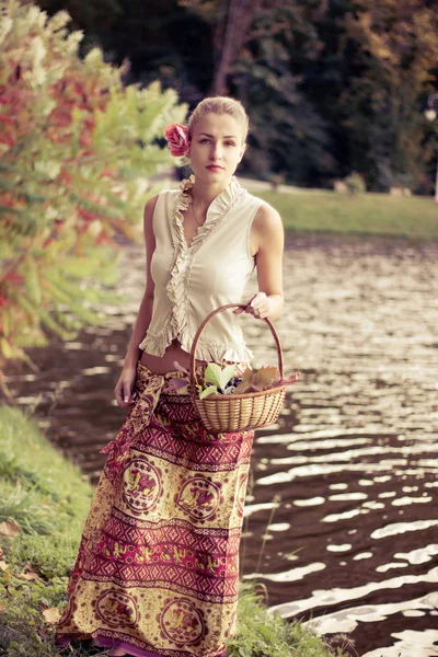 Ładna dziewczyna w czerwonej sukience jesienią w lesie — Zdjęcie stockowe