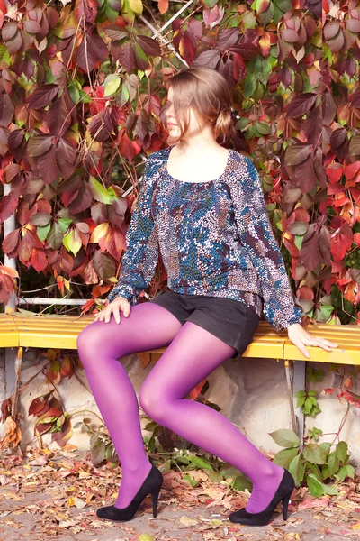 Krásná dívka v fialové punčocháče na podzim — Stock fotografie