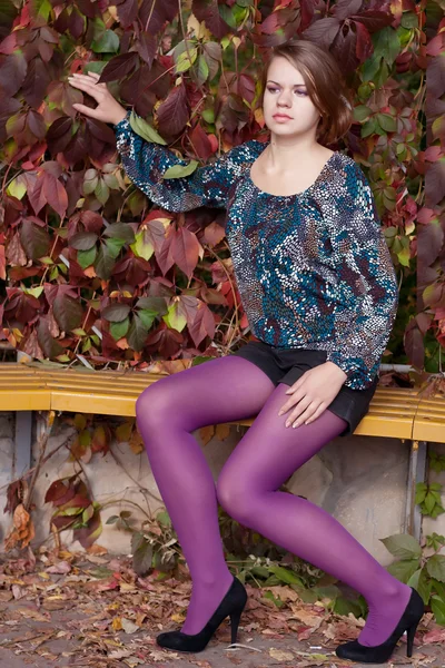 Όμορφο κορίτσι σε μοβ καλσόν το φθινόπωρο — Φωτογραφία Αρχείου