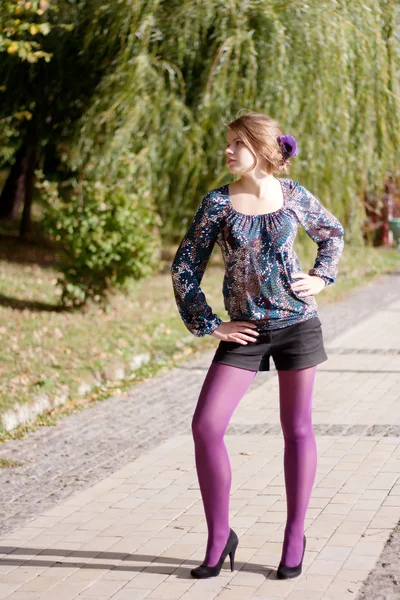 Красивая девушка в фиолетовых колготках осенью — стоковое фото