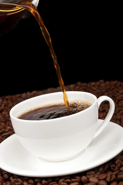 Copo branco com café e grãos de café — Fotografia de Stock