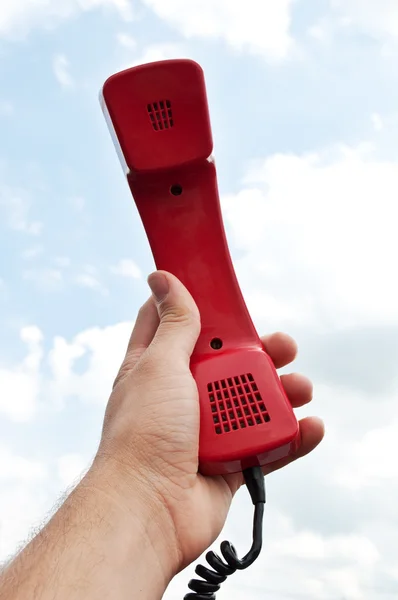 Homem segurando um telefone vermelho — Fotografia de Stock