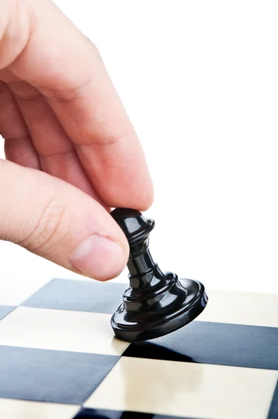 Hand und eine Schachfigur auf dem Brett Stockfoto