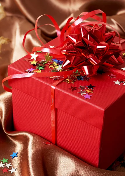 Красная подарочная коробка с луками и звездами — стоковое фото