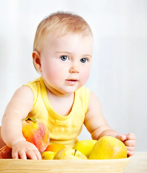 Kleine baby met vruchten — Stockfoto