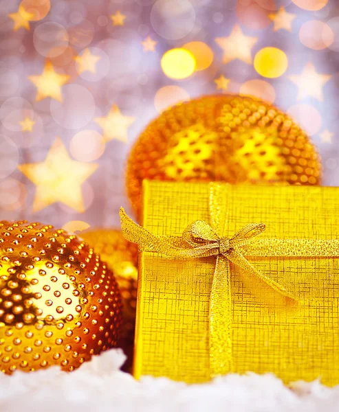 Presente de Natal dourado com decorações de bugigangas — Fotografia de Stock
