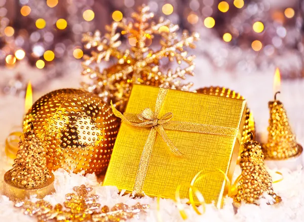 Presente de Natal dourado com baubles decorações e velas — Fotografia de Stock