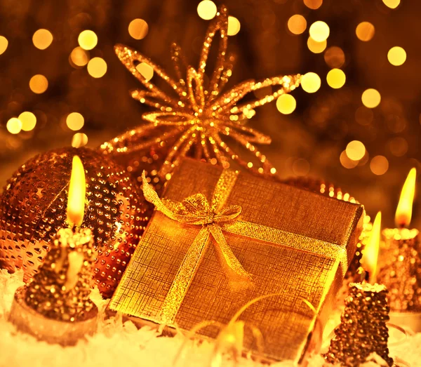Presente de Natal dourado com baubles decorações e velas — Fotografia de Stock