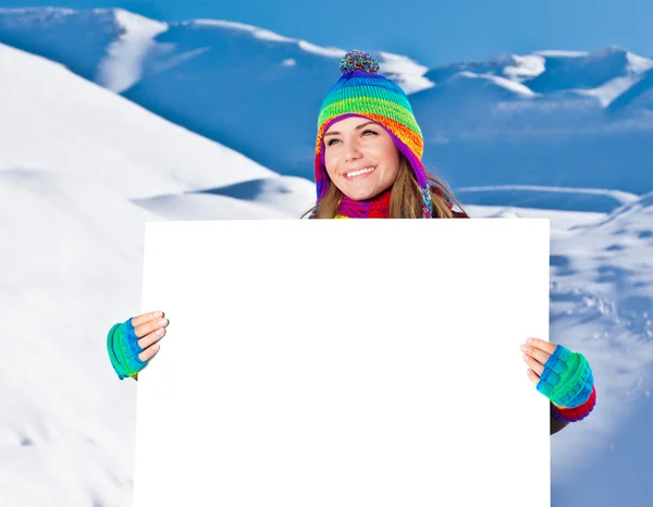 Happy girl holding white board, winter outdoor