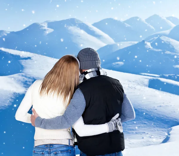 Lyckliga paret kramas utomhus på vintern berg, bakifrån — Stockfoto