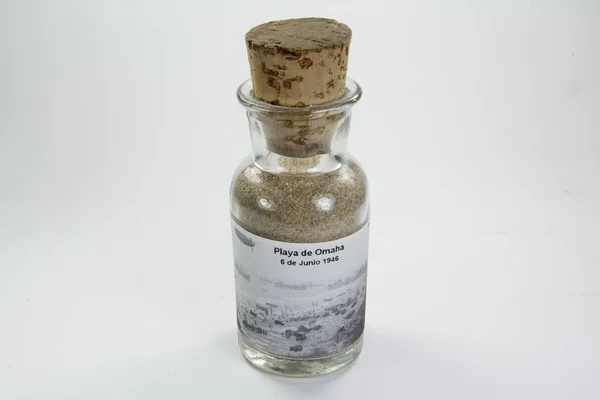 Skleněná láhev s písek z pláže omaha — Stock fotografie