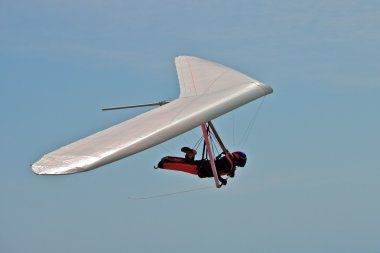 Hang gliding man on a white wing with sky in the background