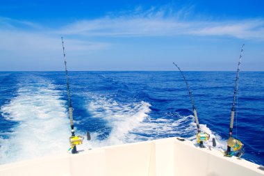 Boat fishing trolling in deep blue sea clipart