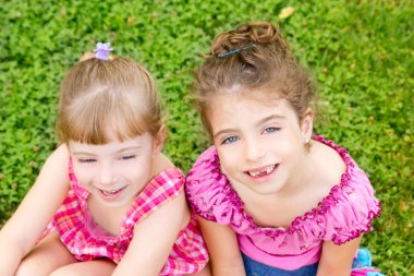 Two sister children girls happy in the grass clipart