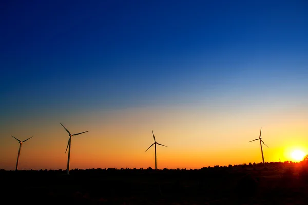 Moinhos de vento aerogenerator no céu por do sol — Fotografia de Stock
