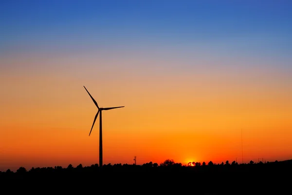 在落日的天空上的风力发电机风车 — 图库照片