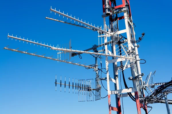 Antenna repeater messy mast in blue sky — Stock Photo, Image