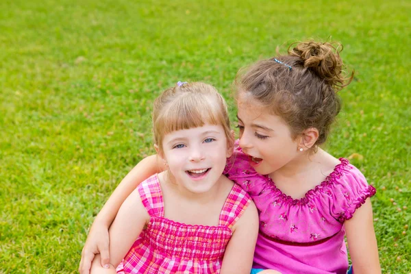 Niños niñas abrazo en verde hierba parque —  Fotos de Stock