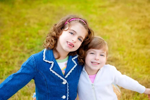 Feliz hermana niñas en invierno parque hierba jugando —  Fotos de Stock