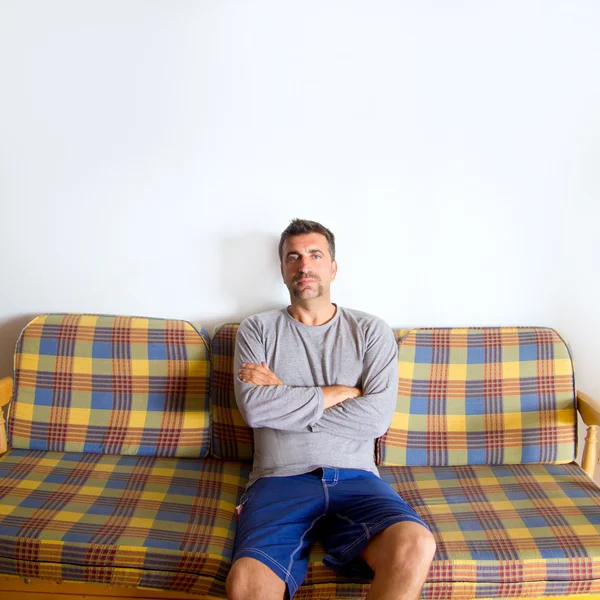 Человек с ретро-усами сидит на винтажном диване — стоковое фото