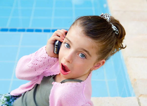 Malá holčička mluví mobilní telefon s překvapením — Stock fotografie