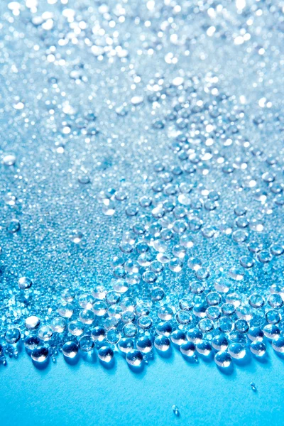 Kristallglasperlen kleine Kugeln Textur auf blau — Stockfoto