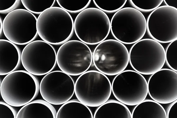 Tubes PVC gris tuyaux en plastique empilés en rangées — Photo
