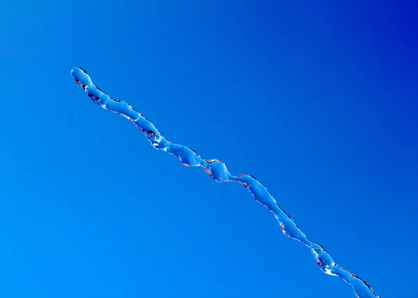 Víz-splash a kék ég háttér — Stock Fotó