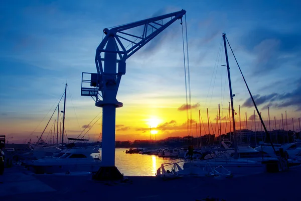 Båtar kranen vid solnedgången i marina hamn i salou — Stockfoto