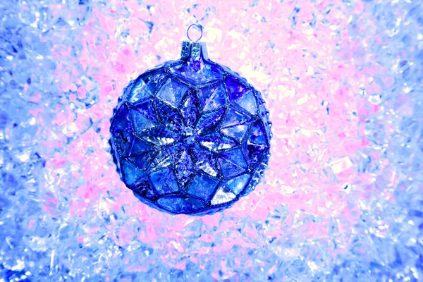 Natale palla di vetro blu sopra ghiaccio rosa blu — Foto Stock