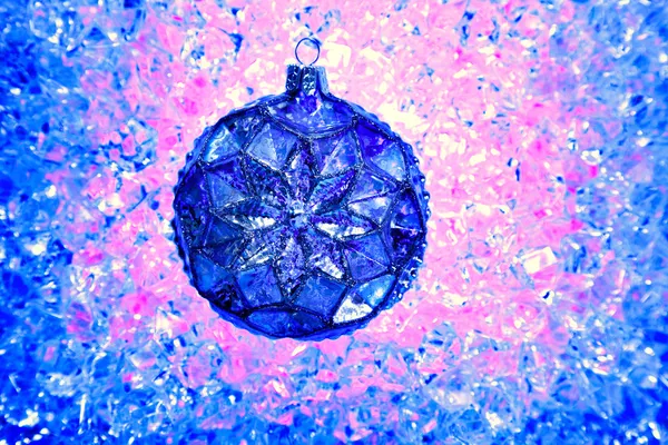 Weihnachtsblaue Glaskugel über Eis rosa blau — Stockfoto