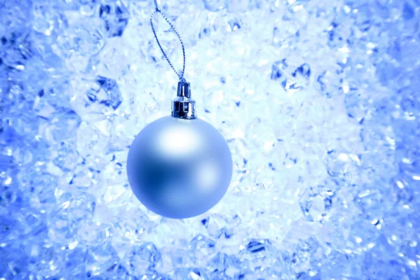 Weihnachtskugel auf blauem Wintereis — Stockfoto